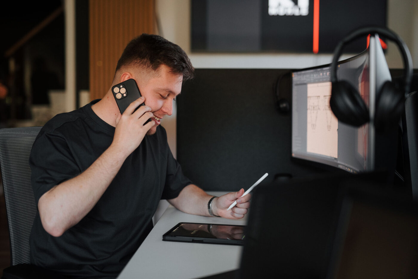 Wie wir arbeiten : Technischer Produktdesigner hat Kontakt per Telefon zu einem Kunden und arbeitet an Konstruktionsplänen am Computer