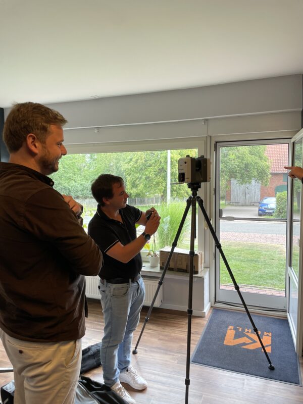 Ein Experte demonstriert den Leica Laserscanner auf einem Stativ bei Möhle Maschinenbau, während Mitarbeiter aufmerksam zuschauen.